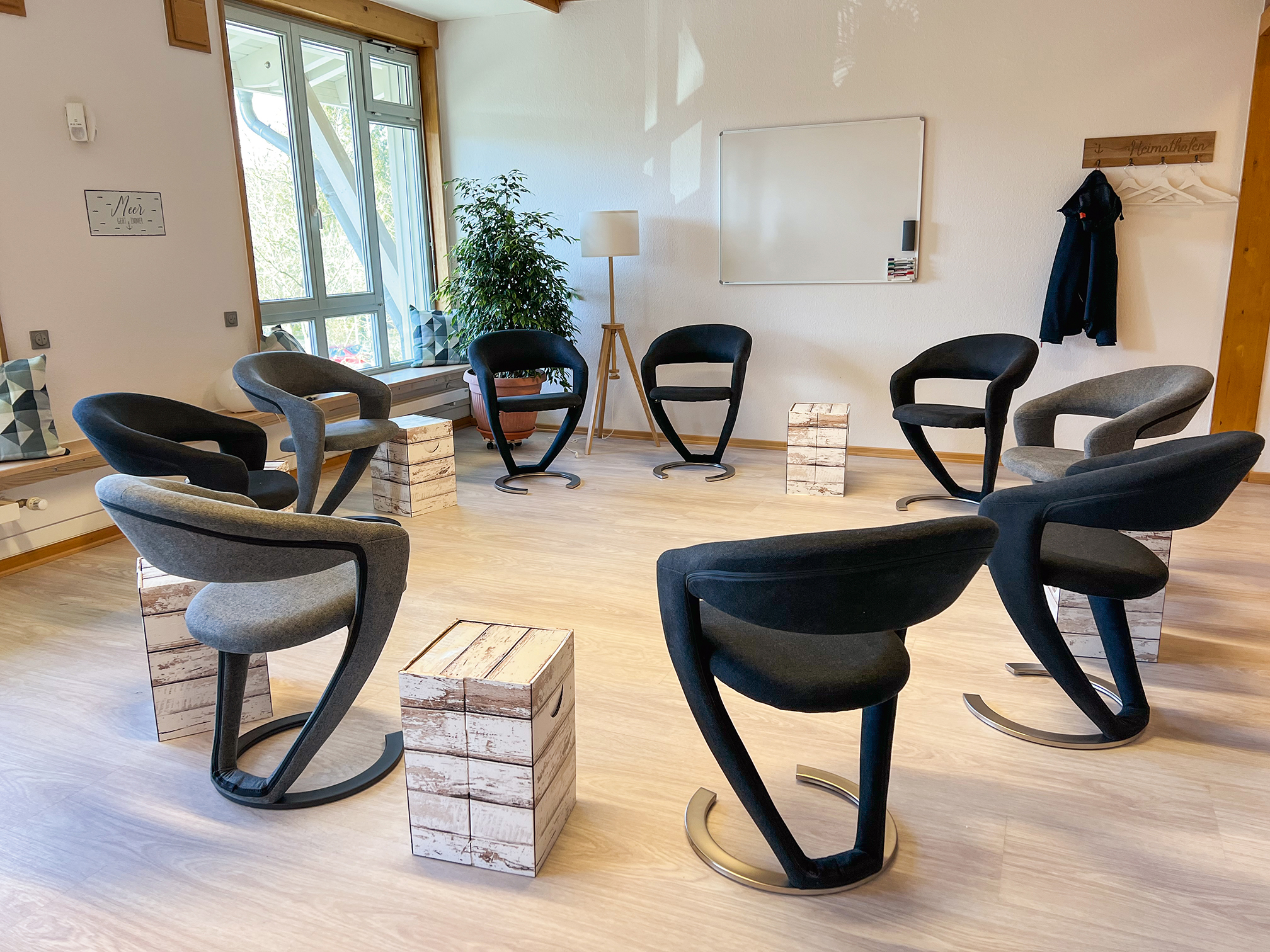 Das Bild zeigt den Seminarraum von Mediation im Norden von Thomas Lorenzen mit 9 Stühlen, Beistelltischen und einem Whiteboard